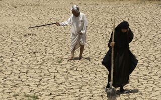 בעל ואישה בודקים את אדמותיהם הצחיחות בגלל הבצורת דרומית לבגדד, עיראק, ביולי 2009 (צילום: AP Photo/Hadi Mizban) בעל ואישה בודקים את אדמותיהם הצחיחות בגלל הבצורת דרומית לבגדד, עיראק, ביולי 2009 (צילום: AP Photo/Hadi Mizban)