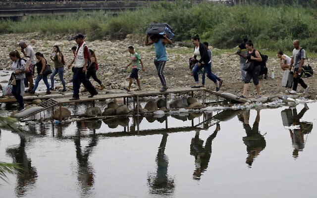 מהגרים מוונצואלה עוברים באופן לא חוקי את הגבול לקולומביה ליד הגשר הבינלאומי סימון בוליבר, 14 באפריל 2019 (צילום: AP Photo/Fernando Vergara, File)