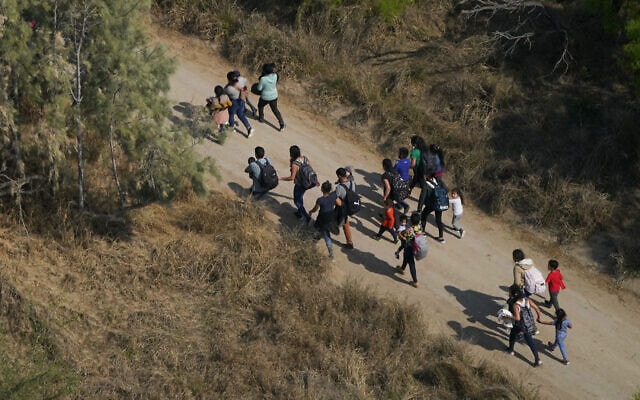 מהגרים בטקסס לאחר שחצו את הגבול ממקסיקו לארצות הברית, 23 במרץ 2021 (צילום: Julio Cortez, AP)