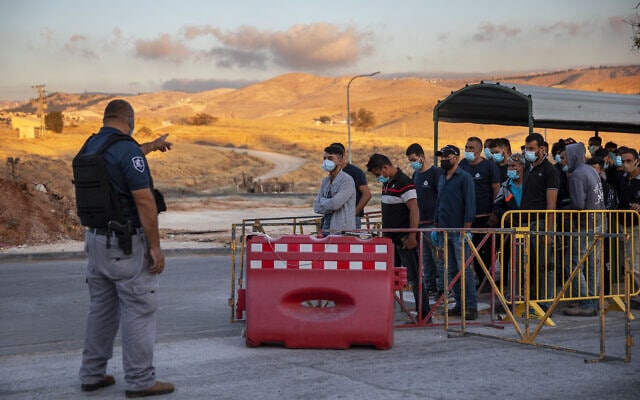 עובדים מהרשות הפלסטינית מחכים לעבור במחסום ליד מעלה אדומים, 30 ביוני 2020 (צילום: AP Photo/Oded Balilty)