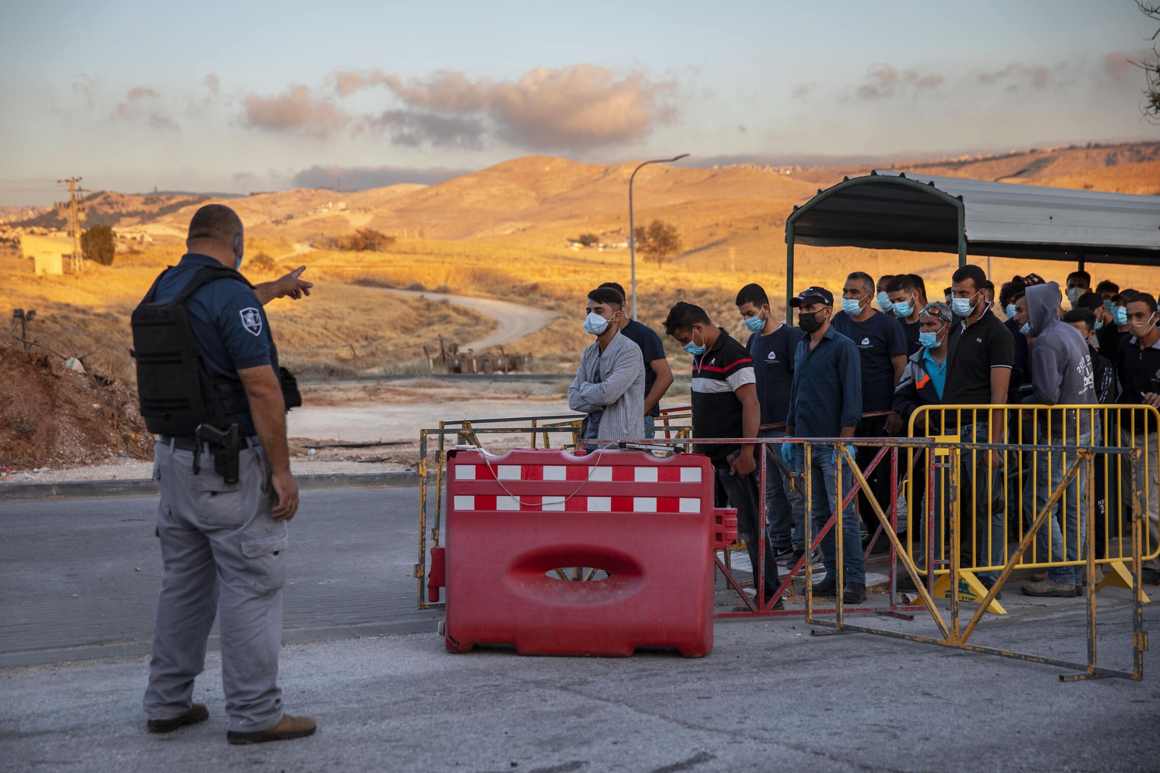 עובדים מהרשות הפלסטינית מחכים לעבור במחסום ליד מעלה אדומים, 30 ביוני 2020 (צילום: AP Photo/Oded Balilty)