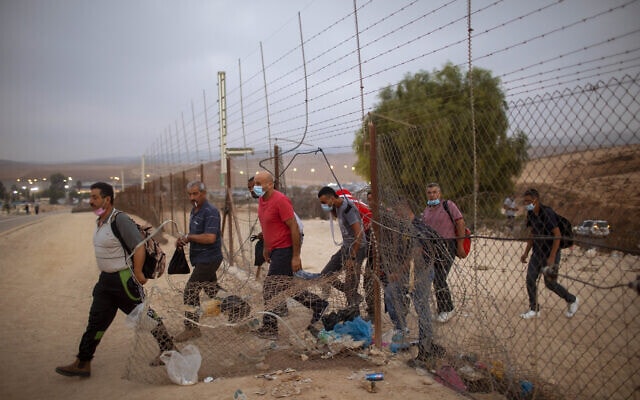 עובדים מהרשות הפלסטינית עוברים דרך פרצה בגדר ליד חברון, 6 בספטמבר 2020 (צילום: AP Photo/Oded Balilty)