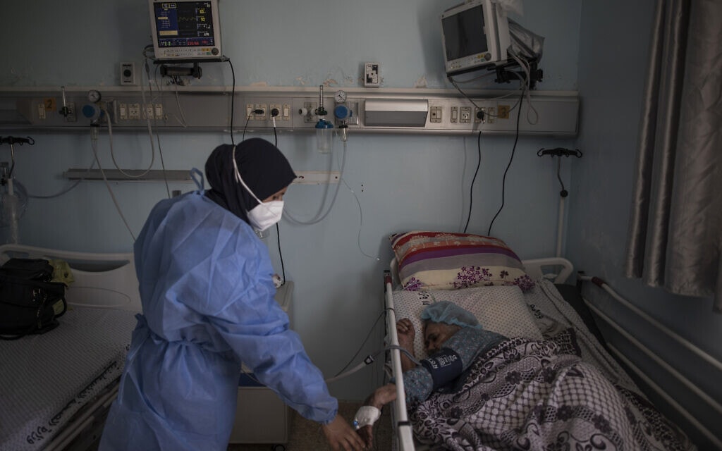 התפרצות הקורונה בעזה: אחות פלסטינית מטפלת בחולה קורונה ביחידה לטיפול נמרץ בבית החולים האירופאי בעזה, 6 במאי 2021 (צילום: AP Photo/Khalil Hamra)