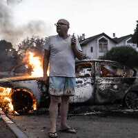 יעקב סימונה ליד מכוניתו שהוצתה בארועים האלימים בלוד, 11 במאי 2021 (צילום: AP Photo/Heidi Levine)