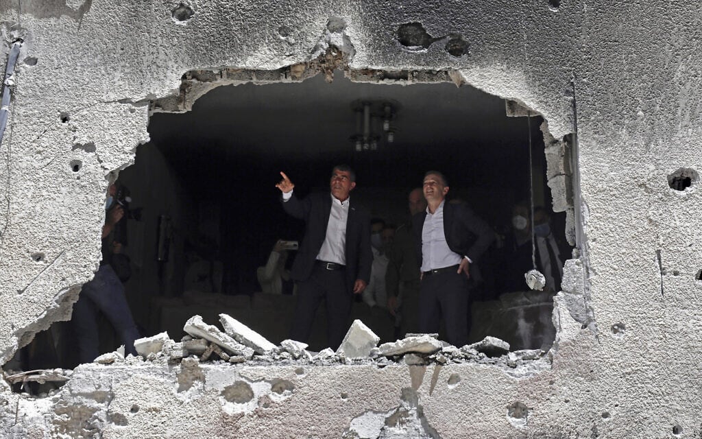 שר החוץ של גרמניה הייקו מאס ושר החוץ גבי אשכנזי מבקרים בבניין בפתח תקוה שנפגע ישירות מרקטה מעזה, 20 במאי 2021 (צילום: AP Photo/Sebastian Scheiner)