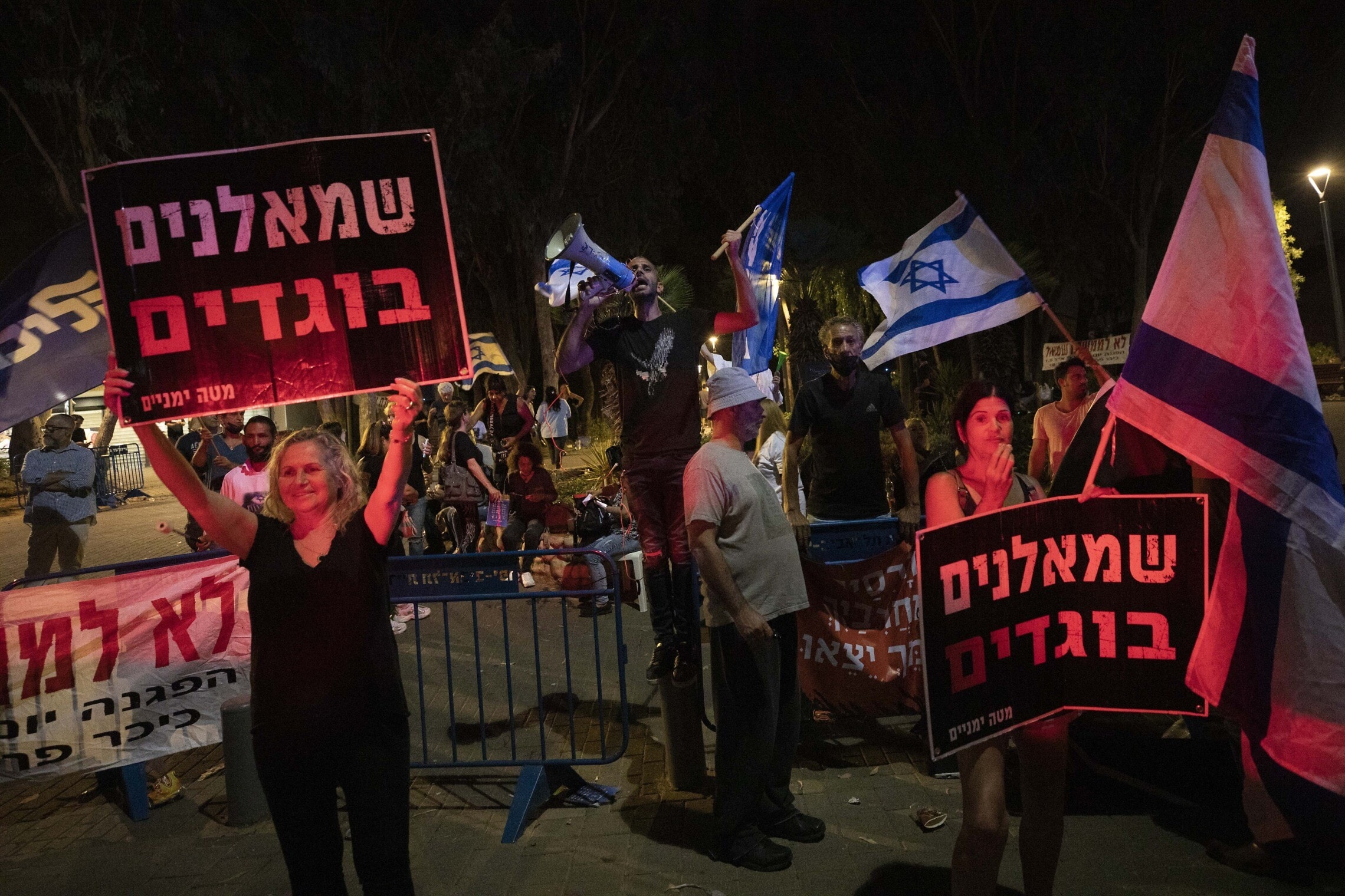 מפגינים מחזיקים בשלטים &quot;שמאלנים בוגדים&quot; בהפגנה מתחת לביתה של איילת שקד, 30 במאי 2021 (צילום: AP Photo/Sebastian Scheiner)