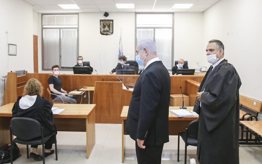 עו&quot;ד מיכה פכטמן ובנימין נתניהו עומדים, התובעת ליאת בן-ארי (משמאל) יושבת מול השופטים ברגע פתיחת משפטו של ראש הממשלה בבית המשפט המחוזי בירושלים, 24 במאי 2020 (צילום: Amit Shabi/POOL)