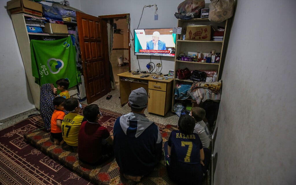 משפחה פלסטינית ברפיח שברצועת עזה צופה בנשיא הרשות הפלסטינית, מחמוד עבאס (אבו מאזן), בטלוויזיה שבביתה, 29 באפריל 2021 (צילום: עבד רחים חטיב, פלאש 90)