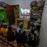 משפחה פלסטינית ברפיח שברצועת עזה צופה בנשיא הרשות הפלסטינית, מחמוד עבאס (אבו מאזן), בטלוויזיה שבביתה, 29 באפריל 2021 (צילום: עבד רחים חטיב, פלאש 90)