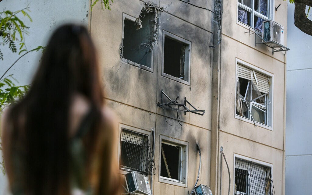 תושבת באשקלון מביטה בבית שספג פגיעה ישירה, 11.5.2021 (צילום: אדי ישראל, פלאש 90) תושבת באשקלון מביטה בבית שספג פגיעה ישירה, 11.5.2021 (צילום: אדי ישראל, פלאש 90)