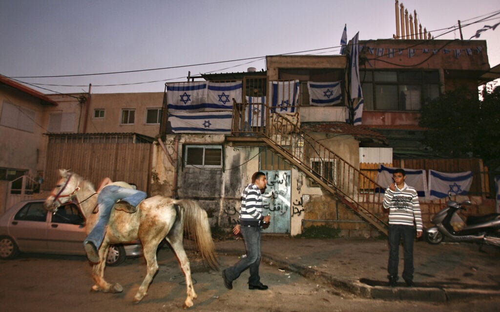פלסטיני עומד מחוץ לבית עם תושבים יהודים בשכונת שייח' ג'ראח ב-2009 (צילום: AP Photo/Dan Balilty)