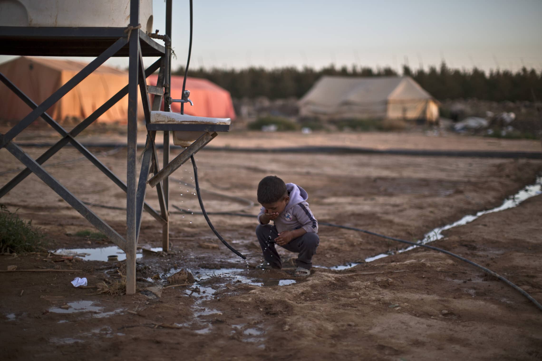 ילד במחנה פליטים בירדן שותה מים (צילום: AP Photo/Muhammed Muheisen)