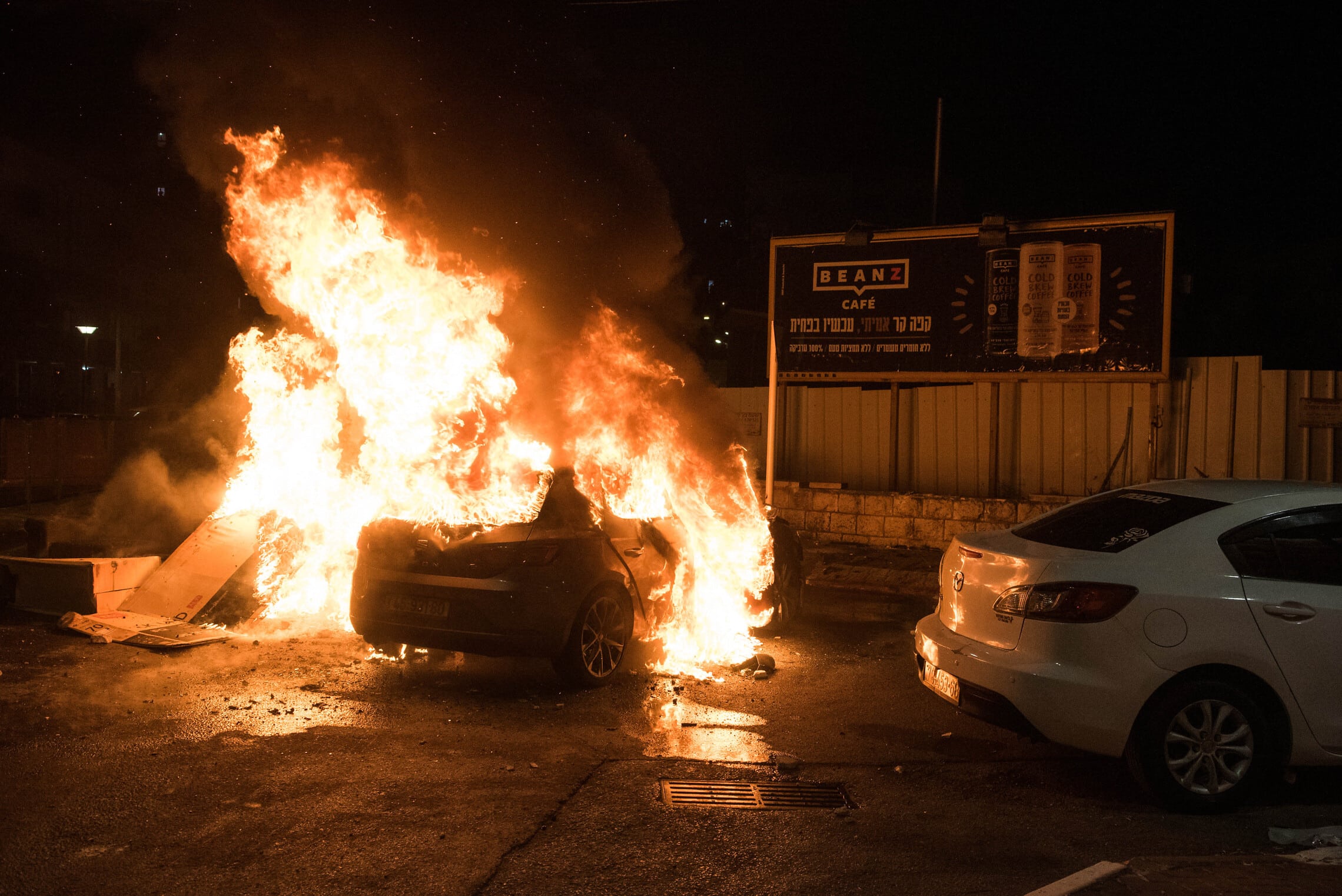 מכונית עולה באש בפרעות שהתרחשו בעכו ב-12 במאי 2021 (צילום: רוני עופר/פלאש90)