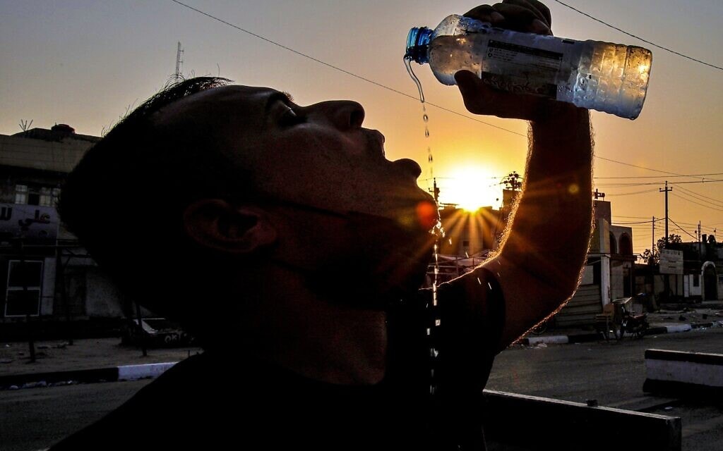 עובד בתחנת דלק בבצרה, עיראק, שותה מים, יולי 2020 (צילום: AP Photo/Nabil al-Jurani)