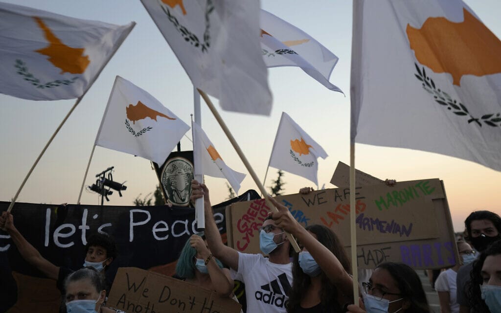 מפגינים מנופפים בדגל קפריסין במחאה על ביקורו של נשיא טורקיה רג&#039;פ טאיפ ארדואן בצפון קפריסין, לרגל 47 שנה לפלישה הטורקית לאי, 19 ביולי 2021 (צילום: AP Photo/Petros Karadjias)