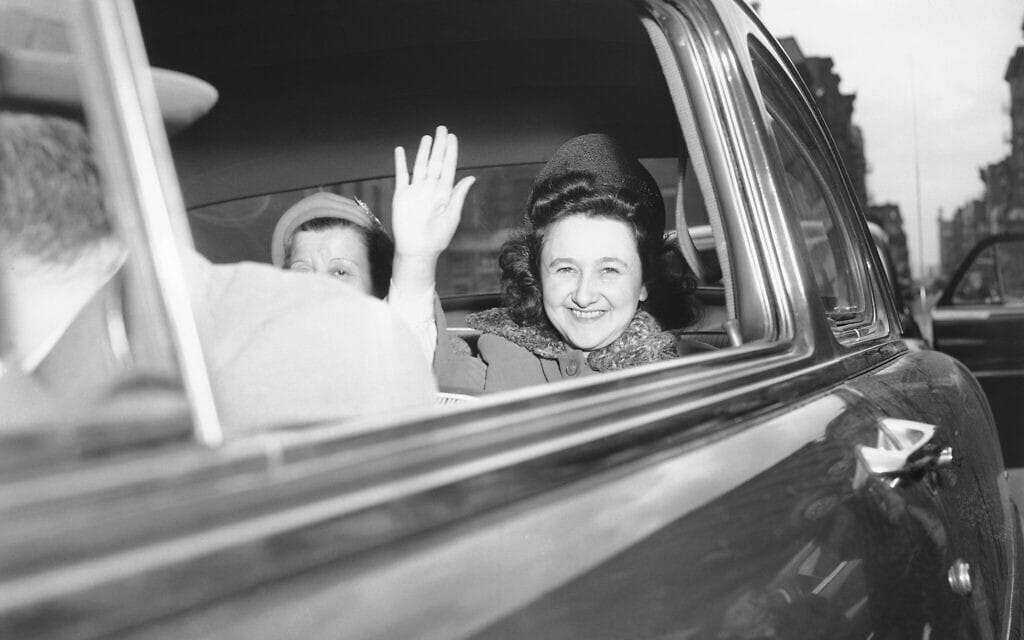 אתל רוזנברג מחייכת ומנופפת בידה כשהיא עוזבת את בית המעצר לנשים בניו יורק, בדרכה לתא הנידונים למוות, 11 באפריל 1951 (צילום: Murray Becker, AP)