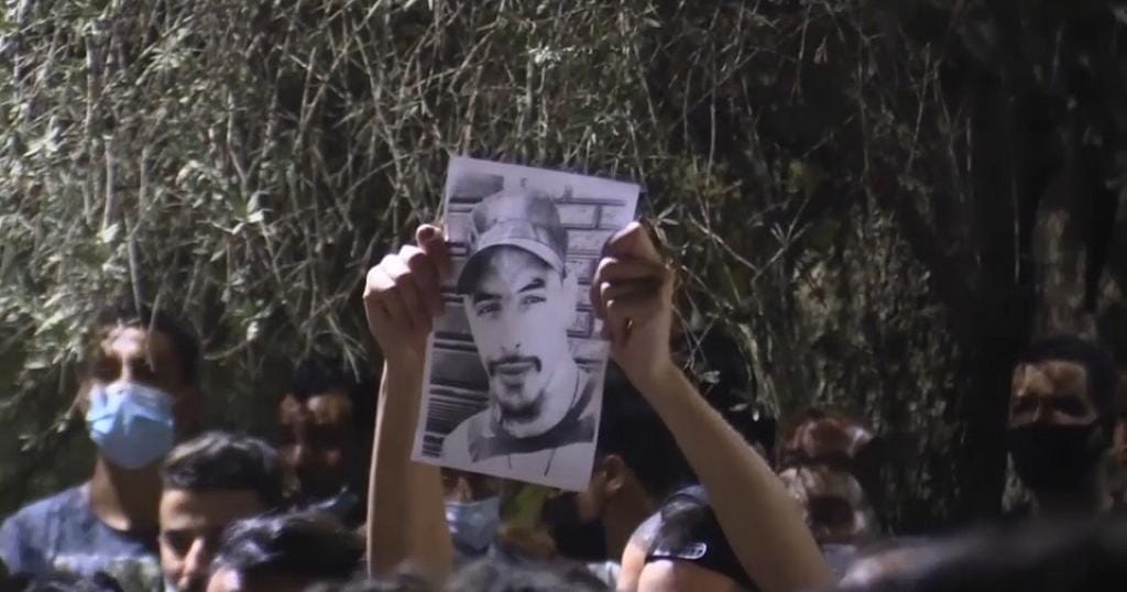 מפגינים אוחזים בתמונה של ג&#039;מיל בן איסמעיל באלג&#039;יריה (צילום: צילום מסך)