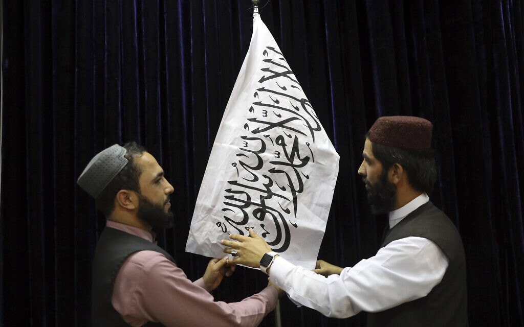 אנשי טליבאן תולים דגל של הארגון לקראת מסיבת עיתונאים עם דובר הטליבאן בקאבול, אפגניסטן, 17 באוגוסט 2021 (צילום: AP Photo/Rahmat Gul)