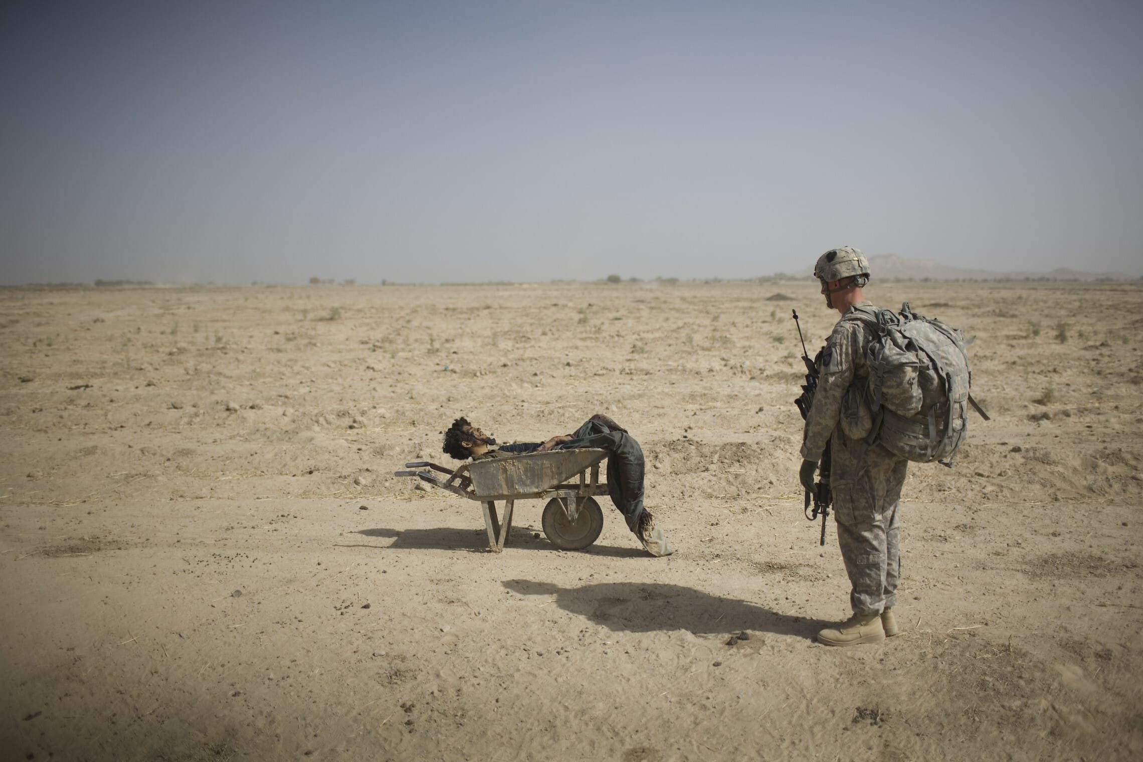 חייל מצבא ארה&quot;ב מביט בגופה של הרוג שנחשד בשיתוף פעולה עם הטליבאן, 10 באוקטובר 2010 (צילום: AP Photo/Rodrigo Abd)
