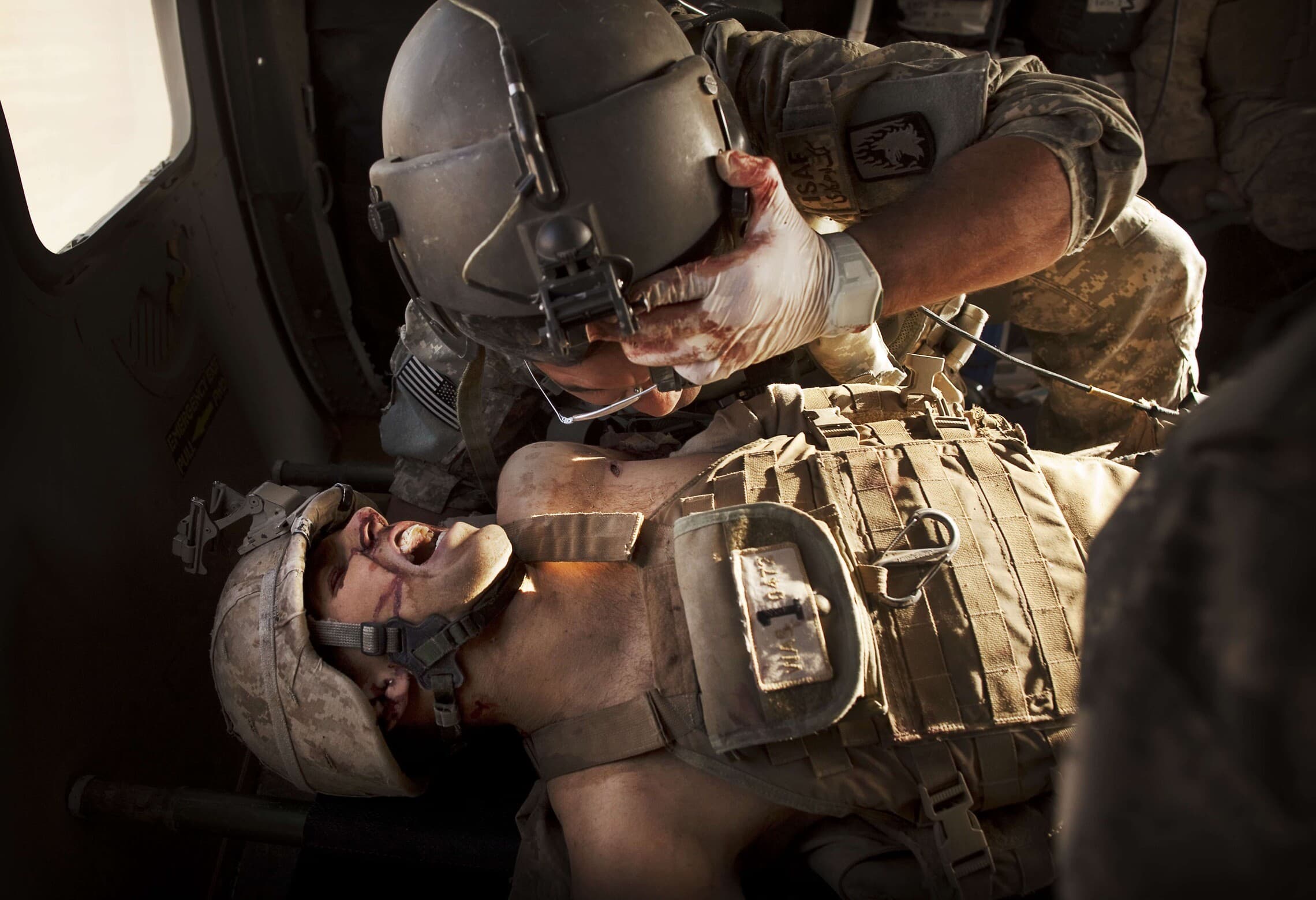 חובש צבאי מטפל בחייל מארינס שנפצע קשה בלחימה באפגניסטן, 15 במאי 2011 (צילום: AP Photo/Kevin Frayer)