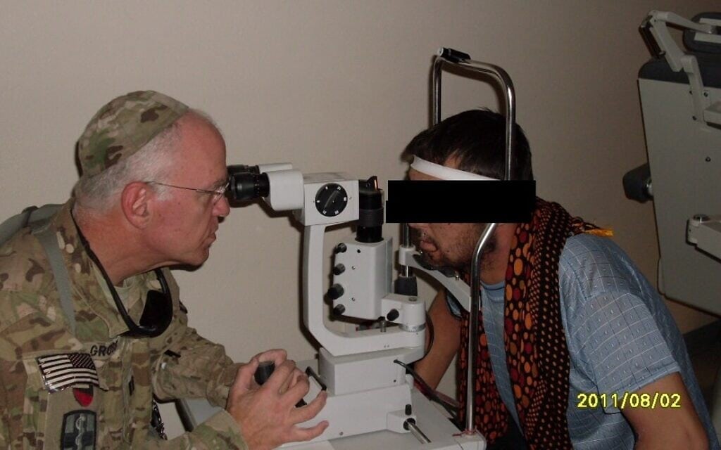 קפטן וורן גרוס (משמאל), מצבא ארצות הברית, בבית חולים צבאי אפגני עם חייל מכוחות הקואליציה האפגניים שסבל מפגיעה בעין, אוגוסט 2011 (צילום: באדיבות וורן גרוס)