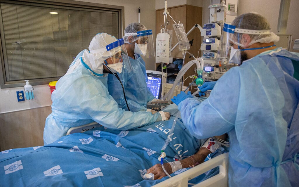 אנשי צוות במחלקת הקורונה של בית החולים הדסה עין כרם מטפלים בחולה, 25 באוגוסט 2021 (צילום: יונתן זינדל, פלאש 90)