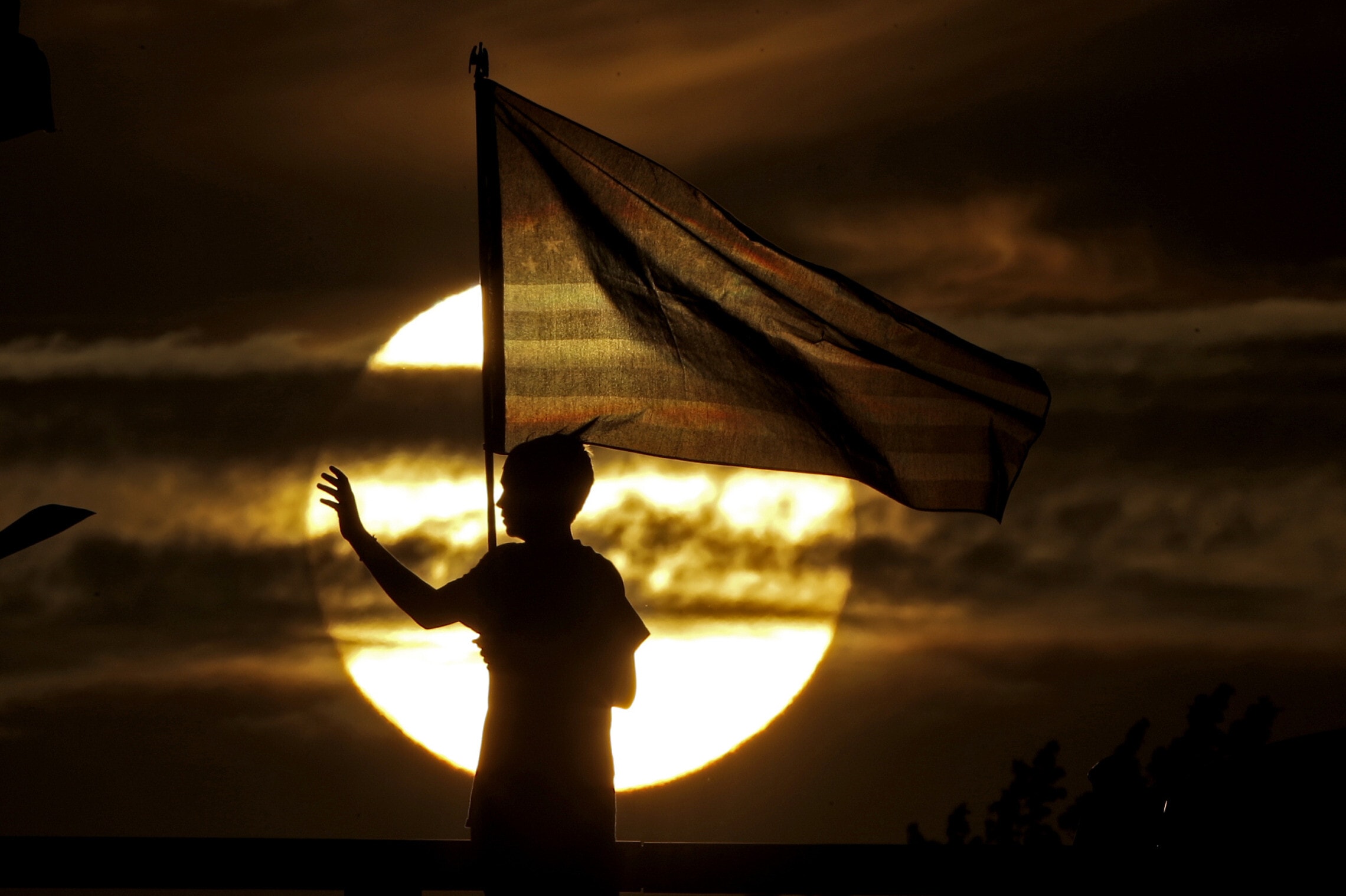 נער מנופף בדגל ארה&quot;ב לנוסעים העוברים בדרכם ליום הזיכרון לארועי ה-11 בספטמבר, ב-2019 (צילום: AP Photo/Charlie Riedel)