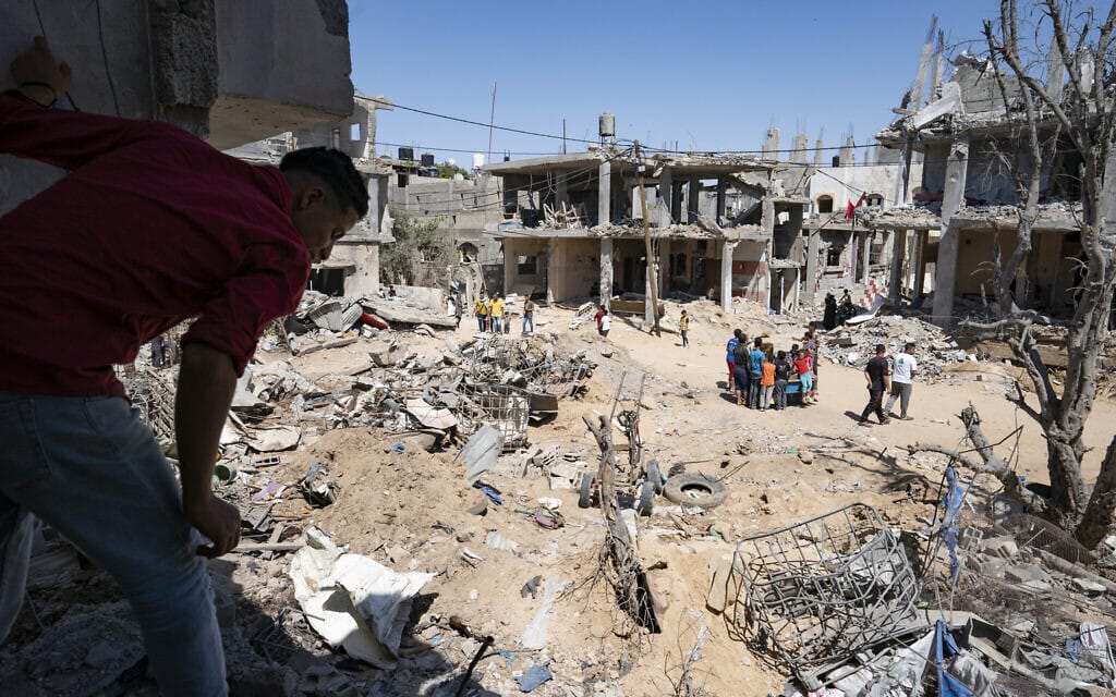 שכנים נאספים בין ההריסות מהתקפה אווירית במהלך העימות בין חמאס לישראל במאי האחרון, בית חאנון, רצועת עזה, 26 במאי 2021 (צילום: John Minchillo/AP)