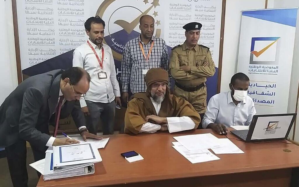 סיף אל-אסלאם קדאפי (משמאל) נרשם לבחירות לנשיאות לוב, 14 בנובמבר 2021 (צילום: Libyan High National Elections Commission via AP)