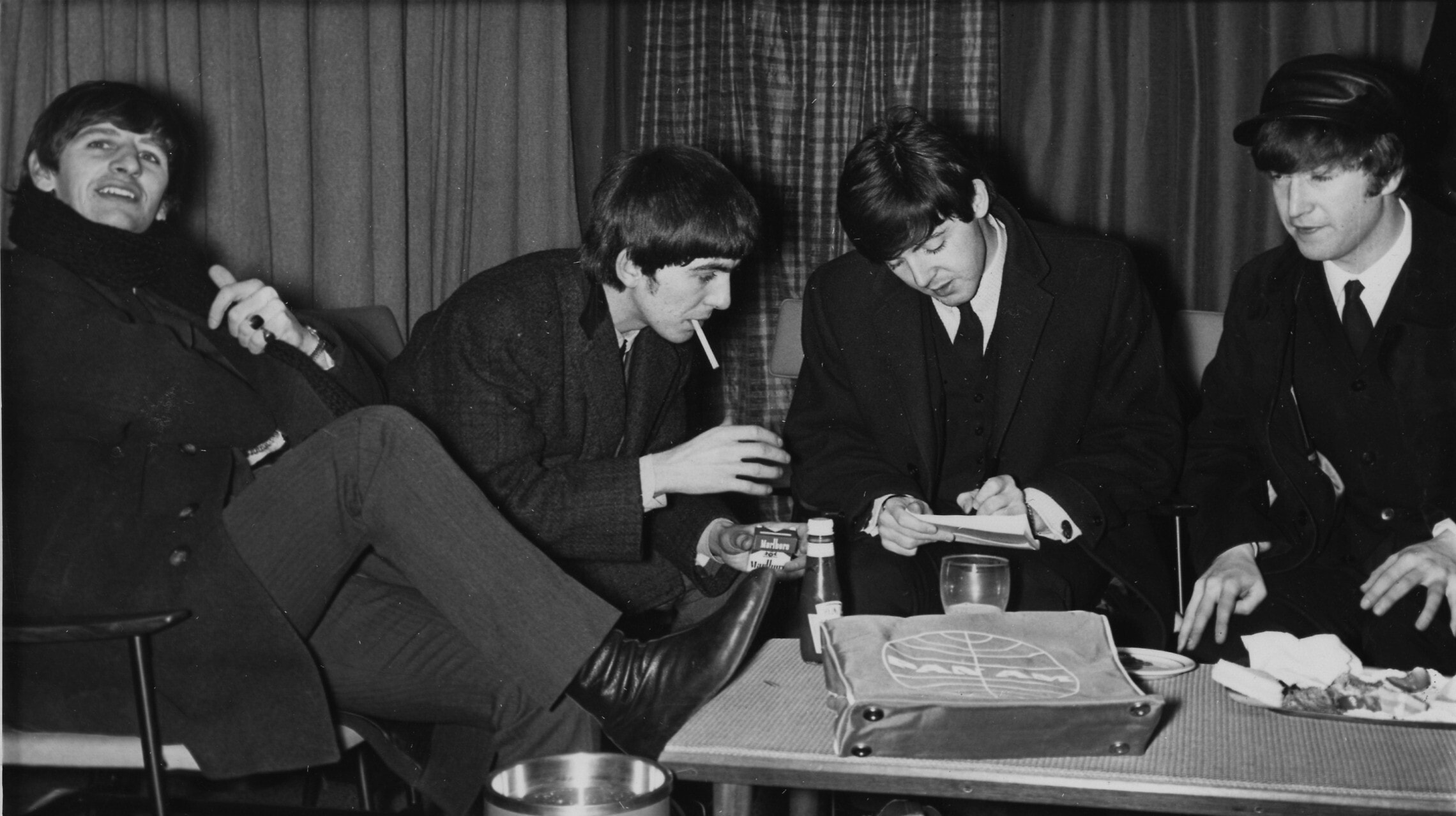 ג&#039;ון לנון, ג&#039;ורג&#039; האריסון, פול מקרטני ורינגו סטאר בשדה התעופה הית&#039;רו בלונדון לקראת המראתם לסיבוב ההופעות הראשון שלהם בארה&quot;ב, 7 בפברואר 1964 (צילום: AP Photo/Victor Boynton)