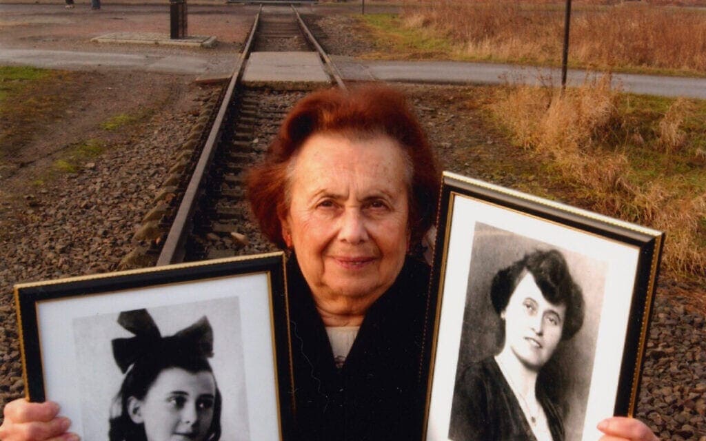 לילי אברט מחזיקה תמונות של אחיותיה בביקור באושוויץ (צילום: באדיבות לילי אברט)