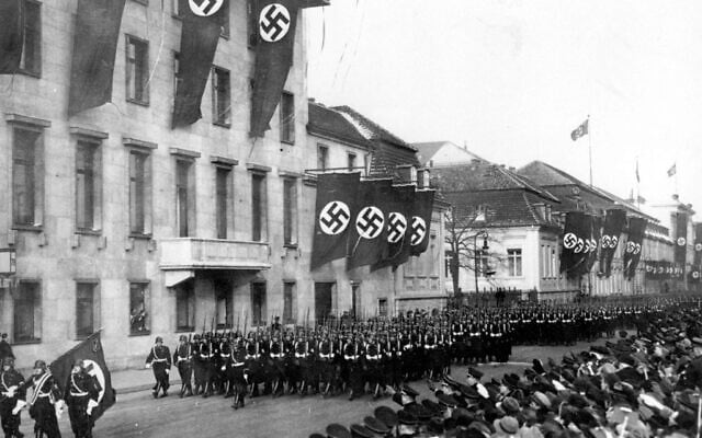 אנשי אס-אס חולפים על פני בניין הקנצלר בווילהלמשטראסה בעת תהלוכה בברלין, גרמניה, 30 בינואר 1937 (צילום: AP)