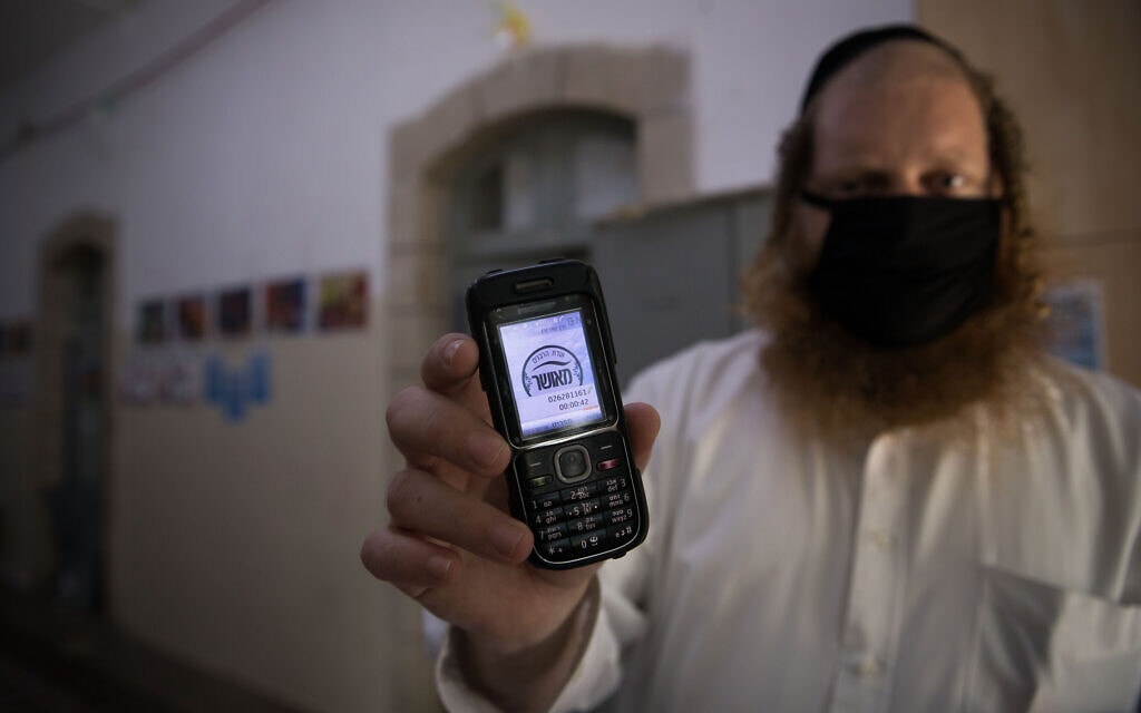 מורה חרדי מחזיק במכשיר טלפון סלולרי "כשר" (צילום: נתי שוחט/פלאש90)