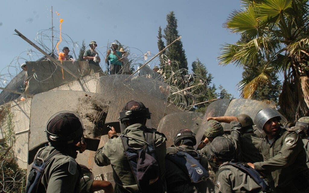 מתנחלים מתבצרים על גג הישיבה בהתנחלות חומש ומתעמתים עם כוחות צה"ל המפנים את המקום במהלך ההתנתקות, 23 באוגוסט 2005 (צילום: פלאש90)