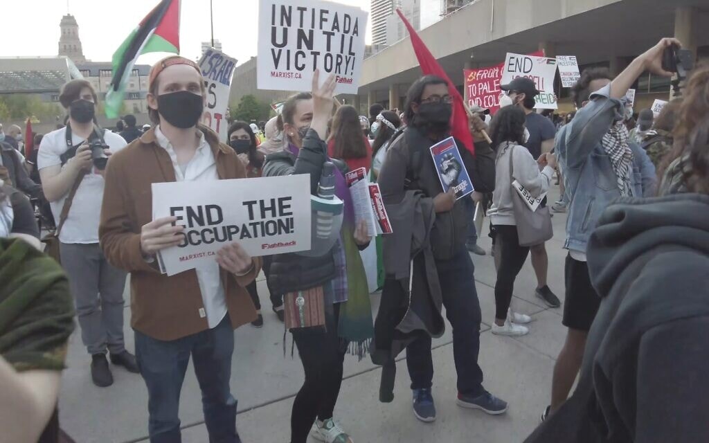 אישה מחזיקה שלט עם הכיתוב &quot;אינתיפאדה עד הניצחון&quot; בהפגנה פרו-פלסטינית שהתקיימה במהלך מבצע שומר החומות בכיכר נייתן פיליפס במרכז טורונטו, 15 במאי 2021 (צילום: יוטיוב)