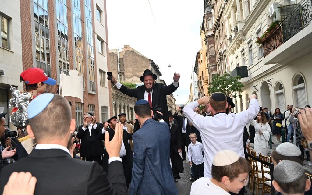 הרב שמוליק אויריכמן על כתפי יהודים הרוקדים לכבוד חנוכת בית הכנסת ברחוב וורוסמרטי בבודפשט, 27 באוגוסט 2021 (צילום: כנען ליפשיץ)