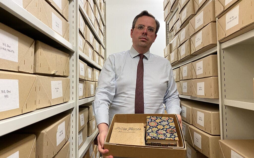 טובי סימפסון מציג מסמך בספריית וינר לחקר השואה במרכז לונדון (צילום: ג'ייקוב ג'ודה)