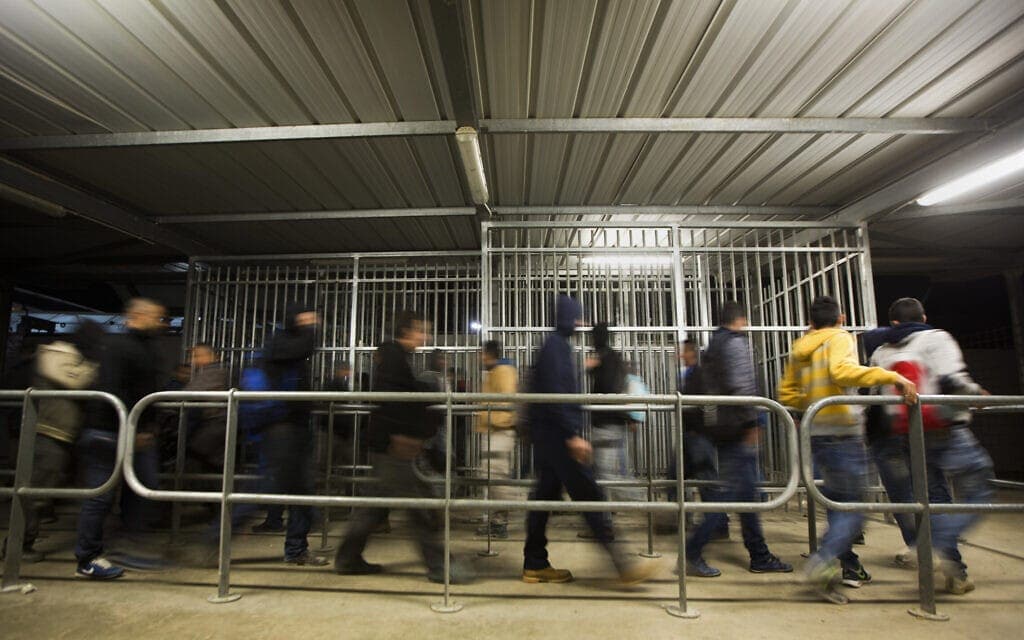 פלסטינים עומדים בתור להיכנס לישראל כדי לעבוד. אילוסטרציה (צילום: AP Photo/Majdi Mohammed)
