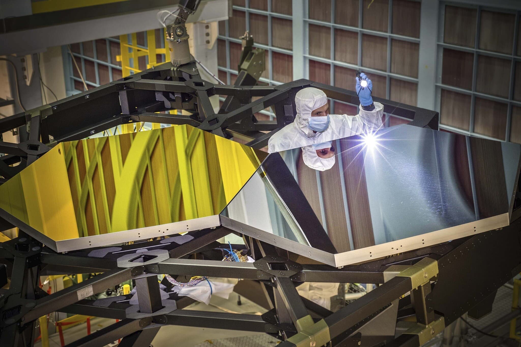 המהנדס האופטי של טלסקופ החלל ג&#039;יימס וב, לרקין קארי, בודק שני מקטעי מראה על דגם אב טיפוס במרכז טיסות החלל גודרד בגרינבלט, מרילנד, 2014 (צילום: כריס גן/נאס&quot;א, באמצעות AP)
