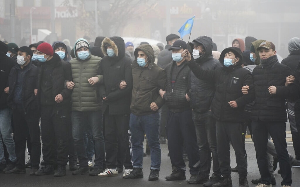 מפגינים קזחים מול שורת שוטרים בקזחסטן, ינואר 2022 (צילום: AP Photo/Vladimir Tretyakov)