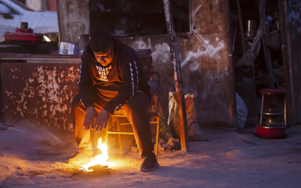 אזרח עיראקי מתחמם ליד מדורה במהלך הקרה שנפלה על המדינה, 19 בינואר 2022 (צילום: AP Photo/Hadi Mizban)
