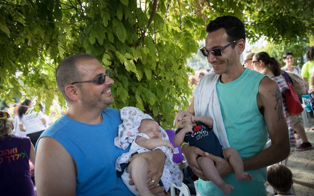 זוג הורים הומואים עם ילדיהם שהובאו לעולם בהליך פונדקאות במצעד הגאווה בירושלים, אוגוסט 2018 (צילום: הדס פרוש/פלאש90)