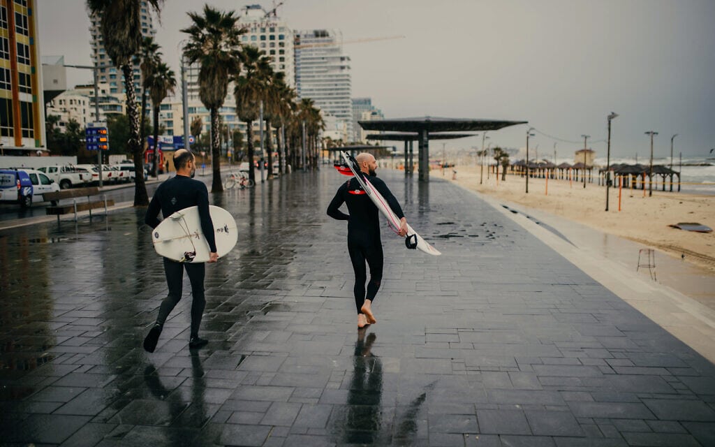 גולשים בטיילת חוף תל אביב ביום גשום. אילוסטרציה (צילום: בן קלמר/פלאש90)