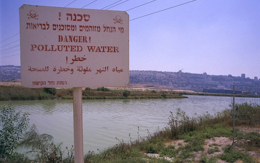 שלט המכריז על "מי נחל הקישון המזוהמים ומסוכנים לבריאות האדם", ליד המפעלים ה"פטרוכימיים" בחיפה ב-30 ביוני 2000 (צילום: משה מילנר/לע"מ)