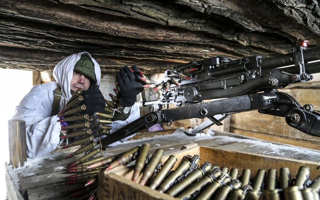 בדלן רוסי בודק את מכונת הירייה שלו במחסה בשטח במזרח אוקראינה, 27 בינואר 2022 (צילום: AP Photo/Alexei Alexandrov, File)