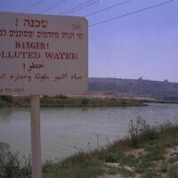 שלט המכריז על "מי נחל הקישון המזוהמים ומסוכנים לבריאות האדם", ליד המפעלים ה"פטרוכימיים" בחיפה ב-30 ביוני 2000 (צילום: משה מילנר/לע"מ)