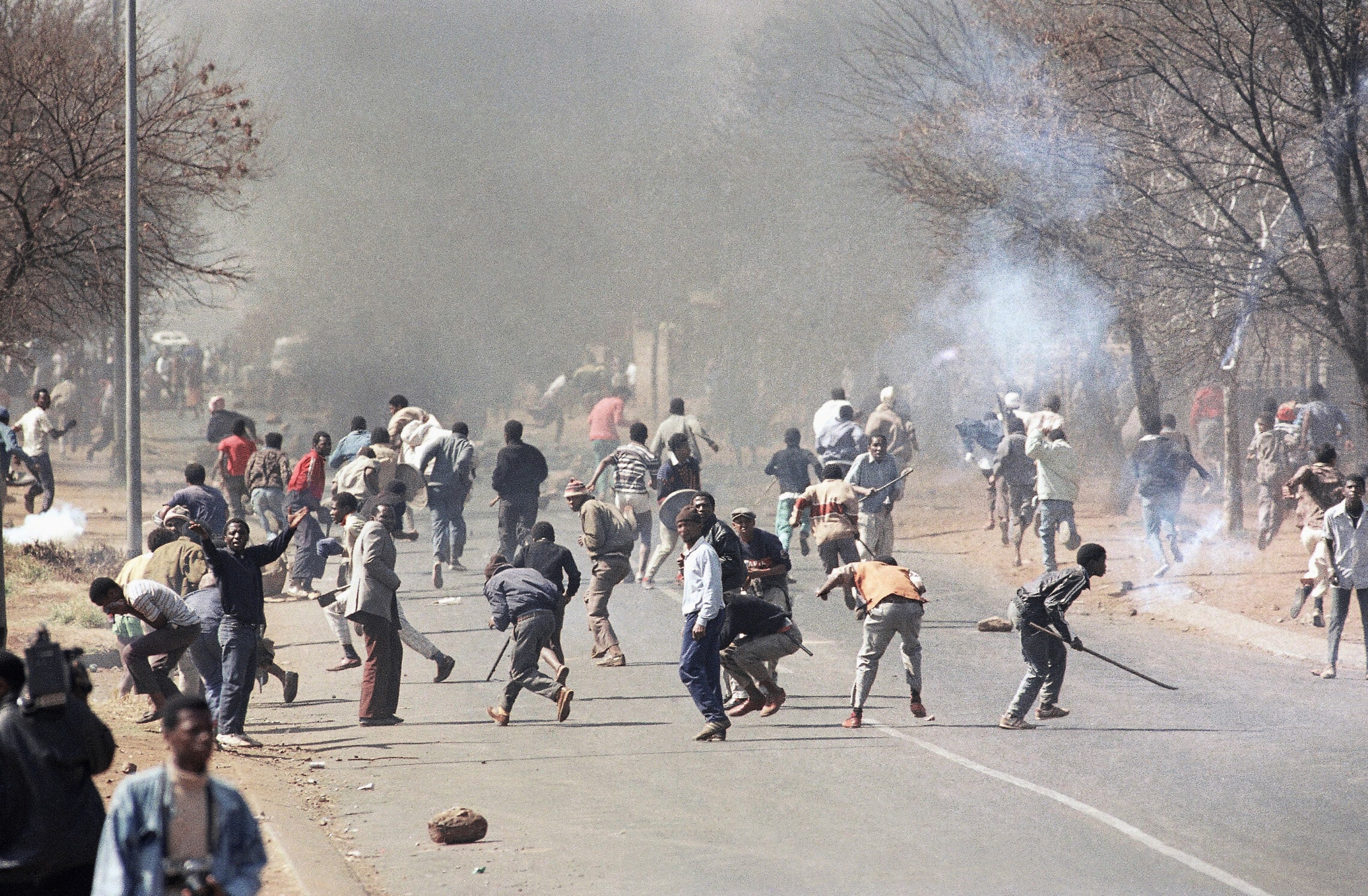 המשטרה בדרום אפריקה בזמן משטר האפרטהייד יורה במפגינים שחורים נגד המשטר. 1990 (צילום: AP Photo/John Parkin/File)