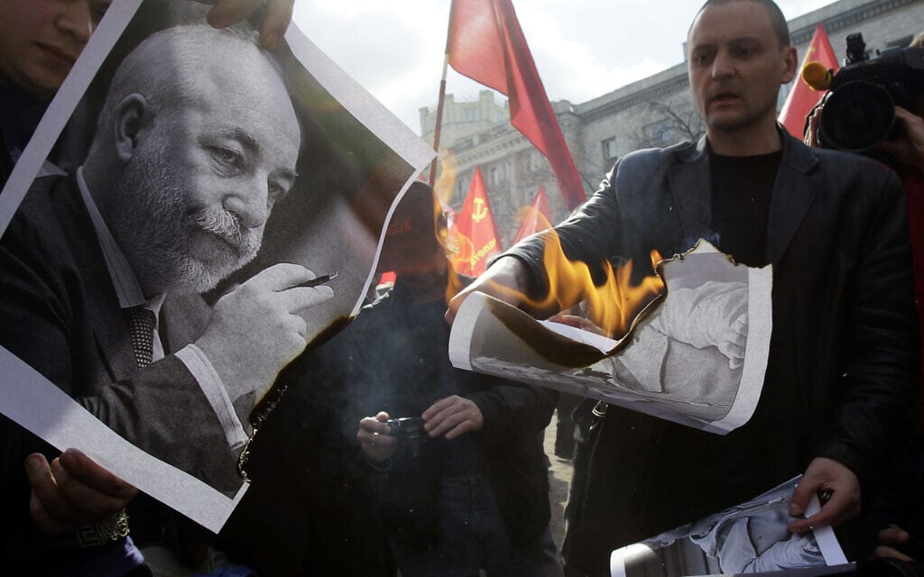 אנשי אופוזיציה שורפים תמונות של אוליגרכים, בהם ויקטור וקסלברג, במהלך עצרת האחד במאי במוסקבה, רוסיה, 2011 (צילום: AP Photo/Ivan Sekretarev)
