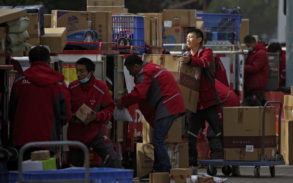 עובדים בחברת שליחויות בבייג'ין מסדרים משלוחים של צ'יפים ושאר מוצרים (צילום: AP Photo/Andy Wong, File)