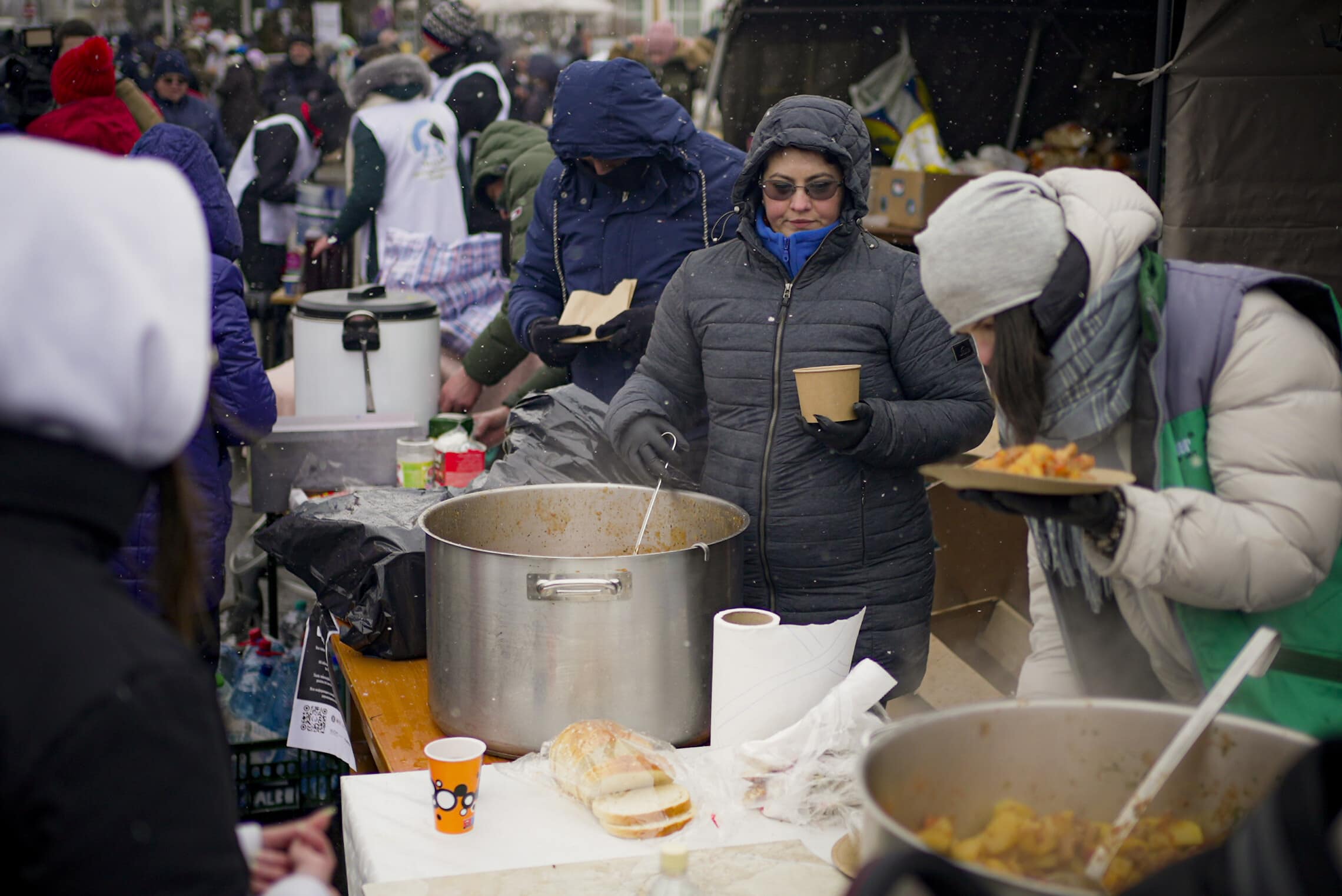 מתנדבים מחלקים אוכל לפליטים אוקראינים בגבול אוקראינה–רומניה, 2 במרץ 2022 (צילום: AP Photo/Renata Brito)
